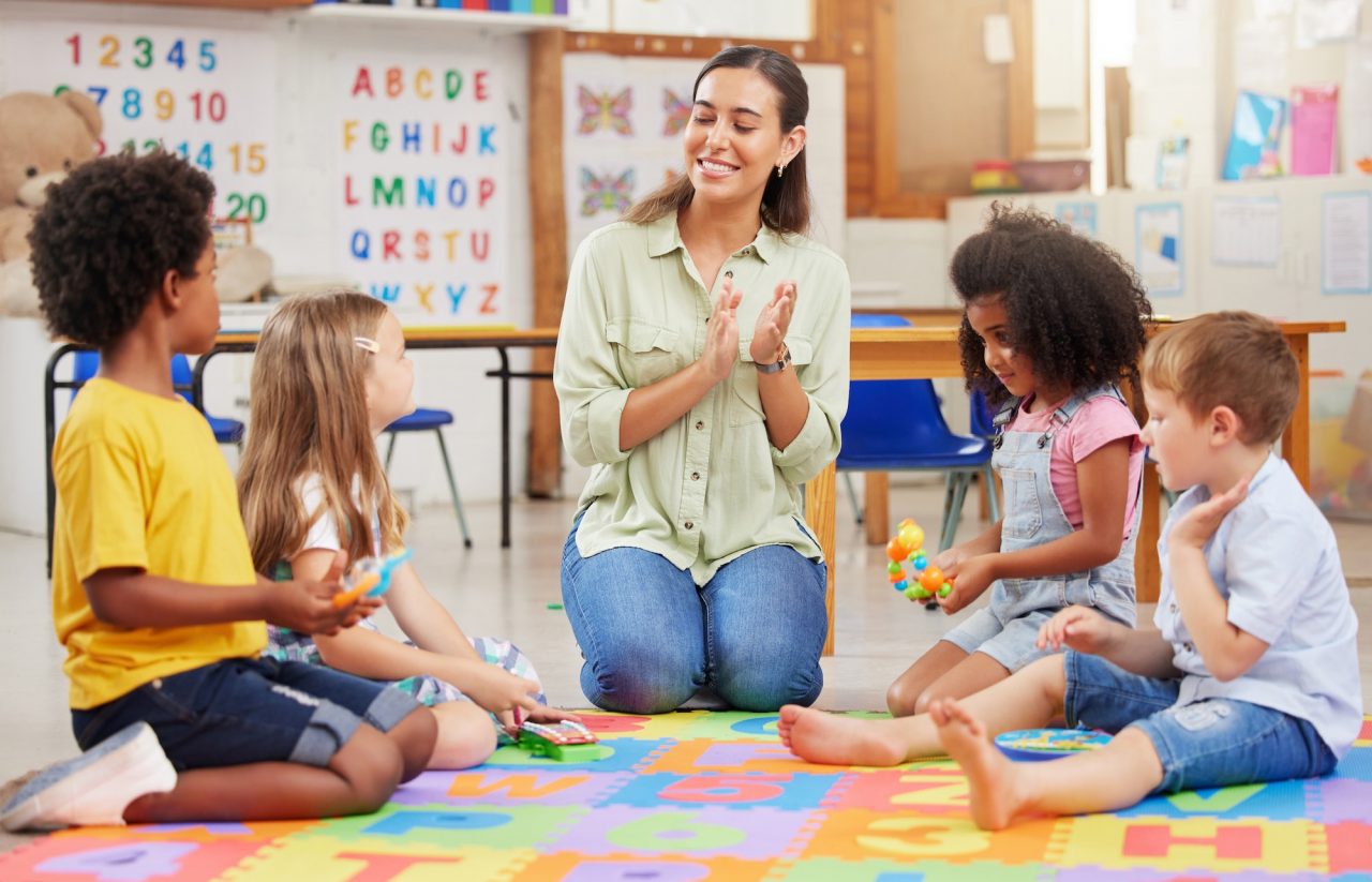 shot of bright stars teacher singing with her preschool children